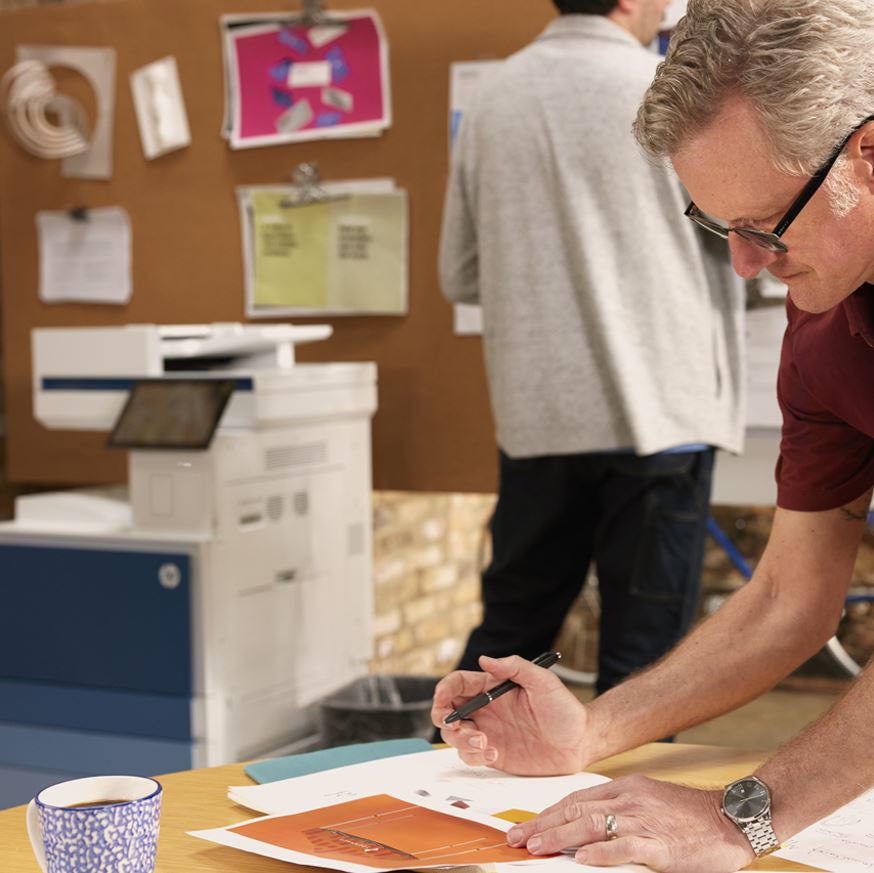 HP Colour LaserJet Managed MFP E786 series in an office setting with two male employees